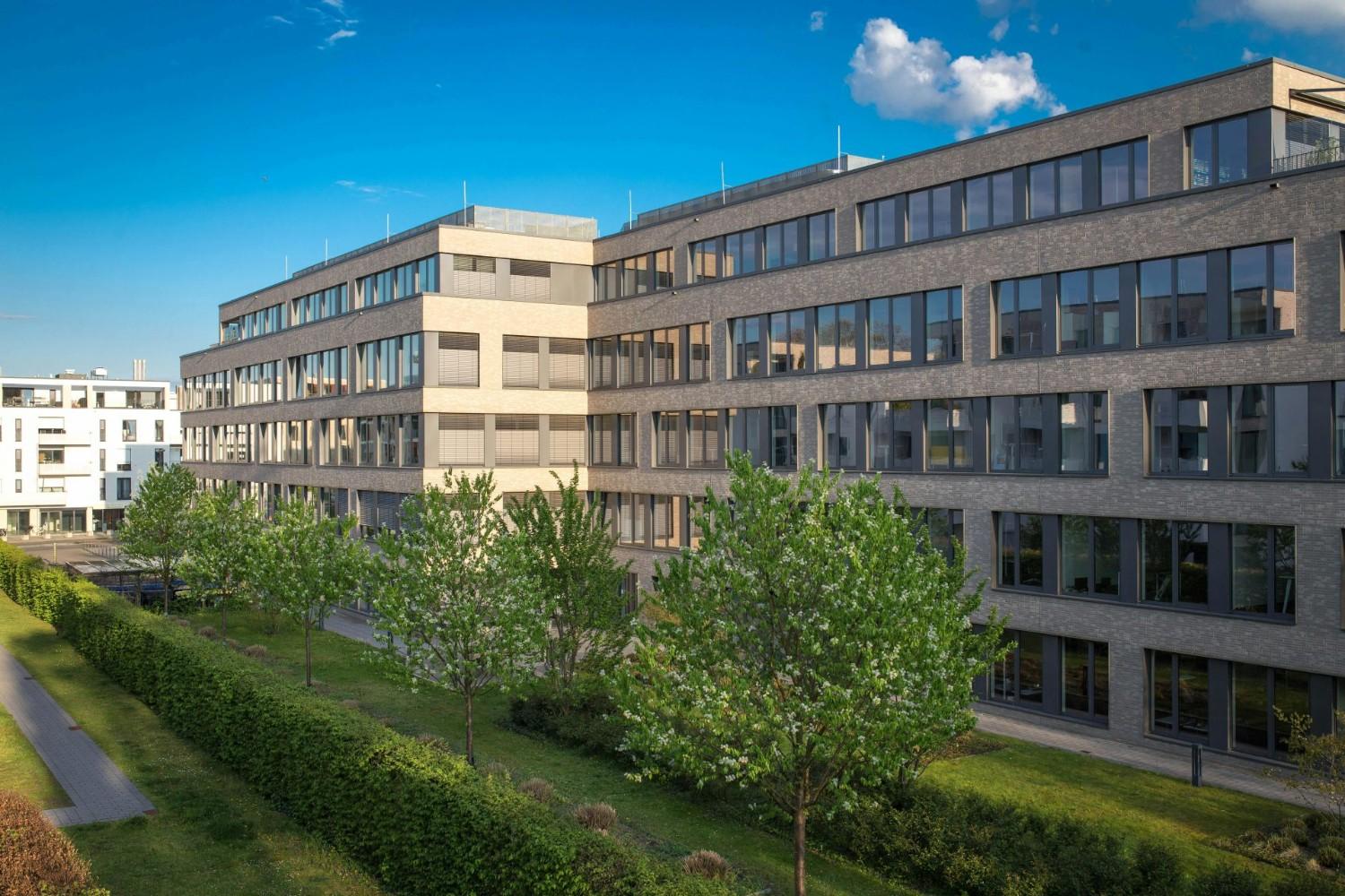 Außenansicht moderner Bürogebäude in Köln, Deutschland, unter strahlend blauem Himmel.